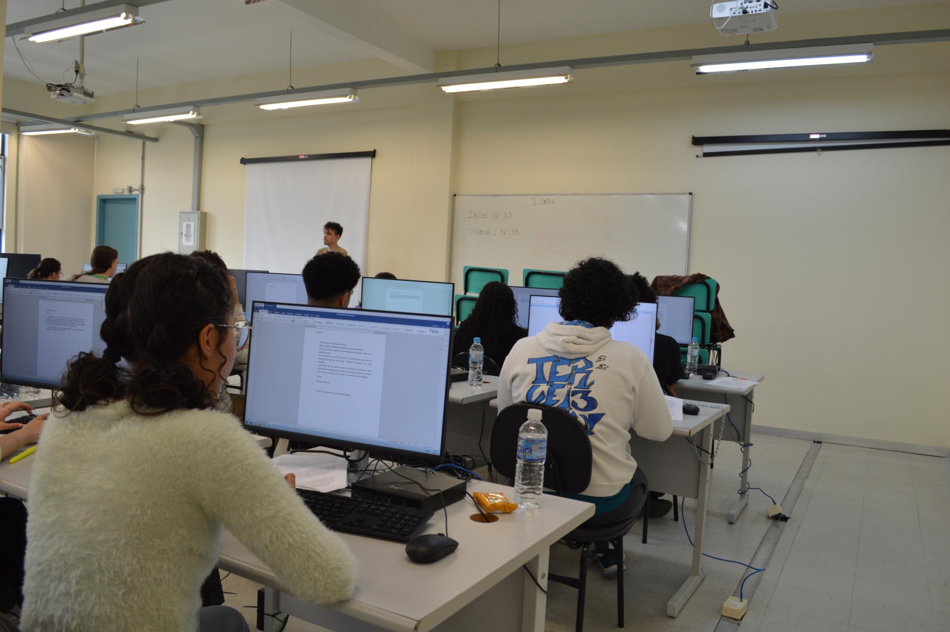 Foto colorida horizontal de estudante ao computador