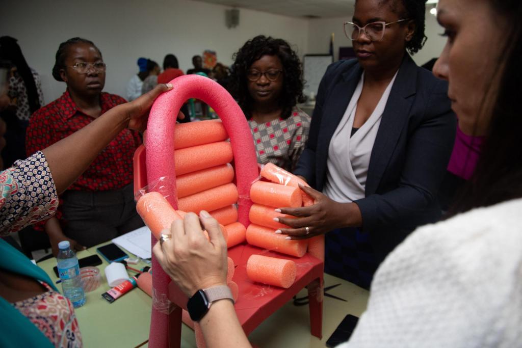 Foto colorida horizontal de grupo de pessoas adaptando cadeira infantil