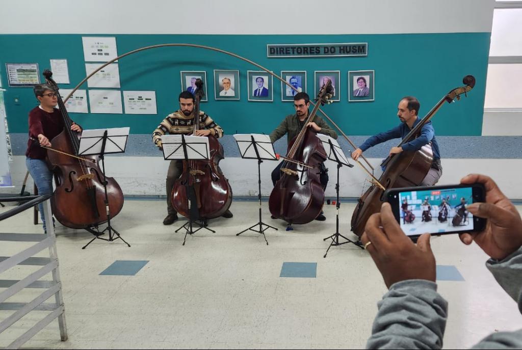 Foto colorida de apresentação de músicos da orquestra no hospital universitário de Santa Maria