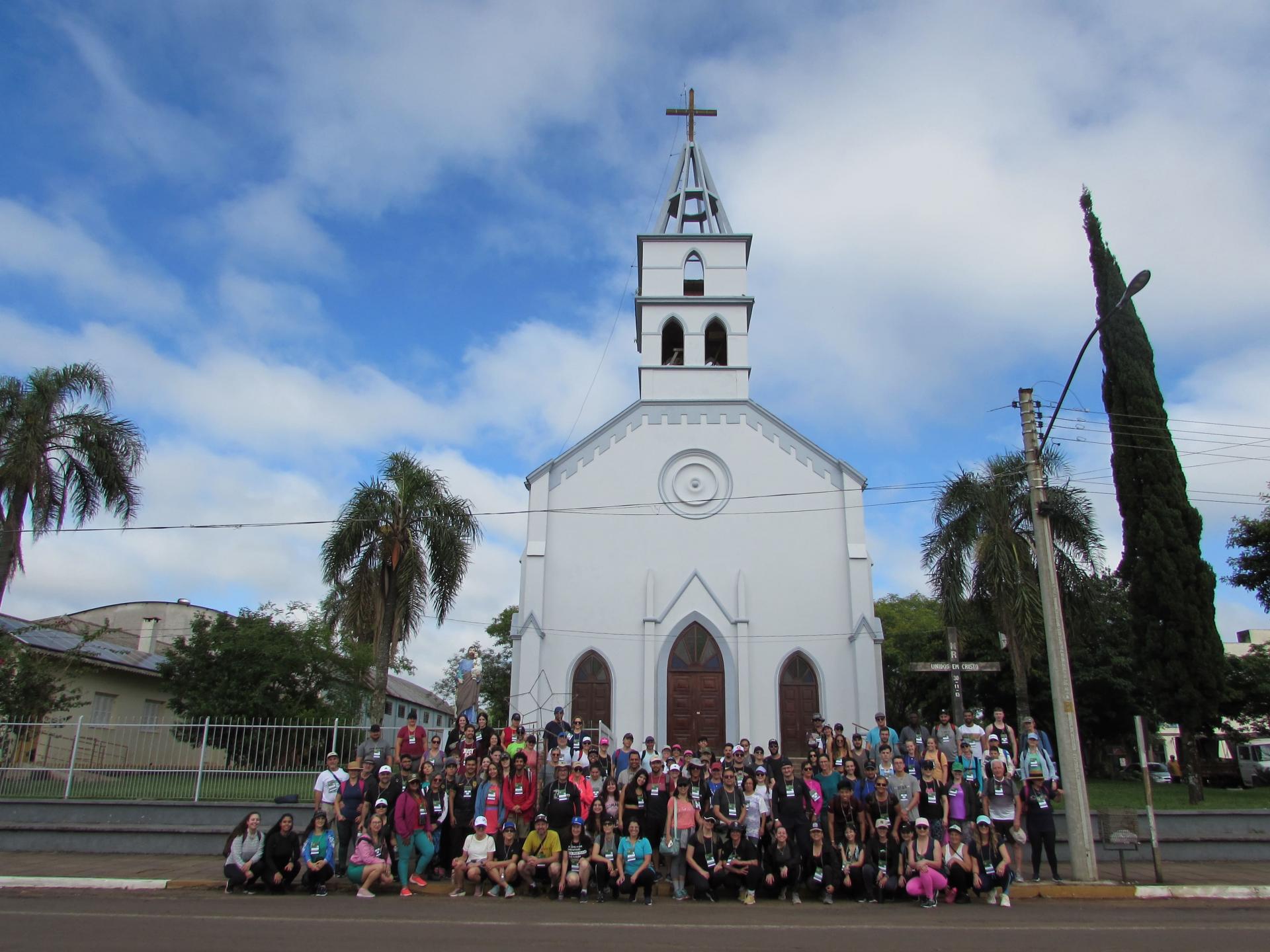 Foto colorida de grupo de pessoas em frente da Gruta Nossa Senhora de Fátima em Nova Esperança do Sul