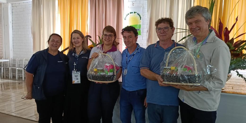 Foto colorida dos professores Nereu e Lilian ao lado de outros organizadores de evento na Fenasoja