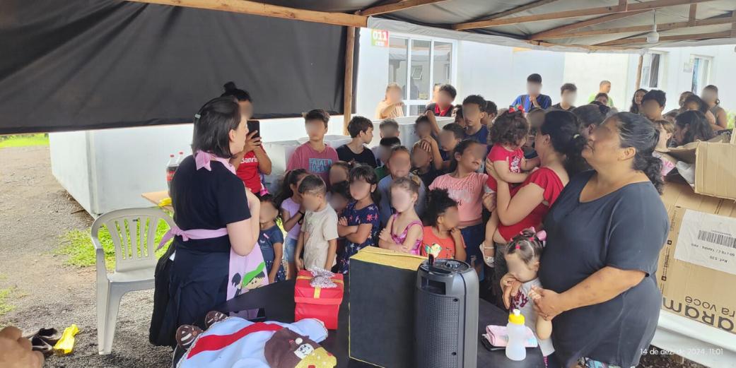 Foto colorida de kits de doces sendo entregues para crianças em Encantado